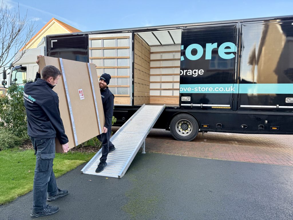 MoveStore movers carrying a crate onto one of their large removal lorries in Edinburgh
